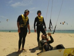 Clase de kitesurf, ejercicios a medida y detallados en la playa antes de salir al agua con la tabala de kitesurf.
